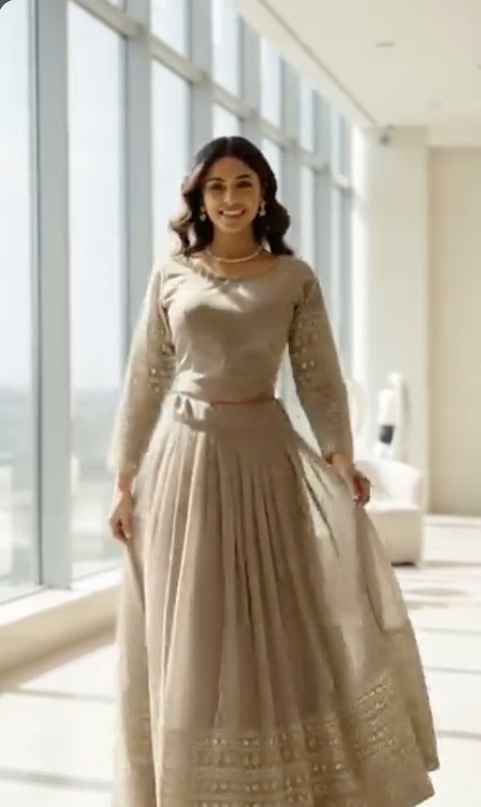 AI model in a ReStyle beige lehenga set by tall windows